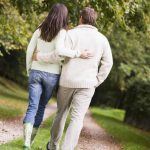 Rear view of couple walking along path